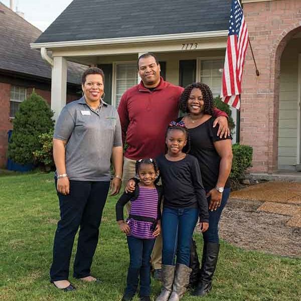 Family posing outside of their first home 